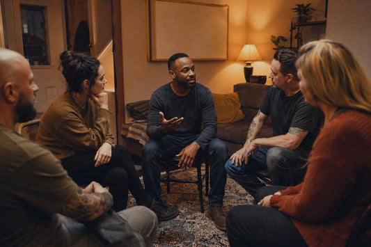a small group of people gathered around a man speaking